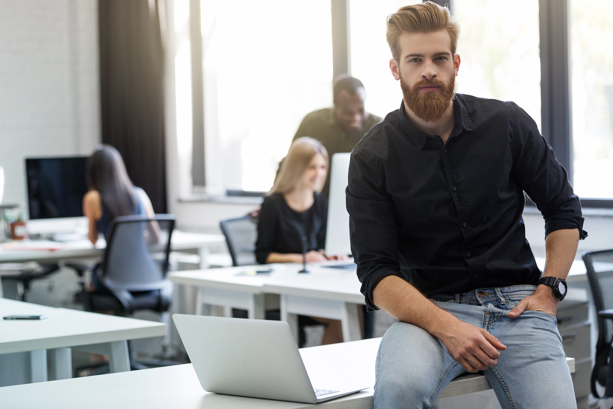 Angebot 9 young bearded man sitting his desk office