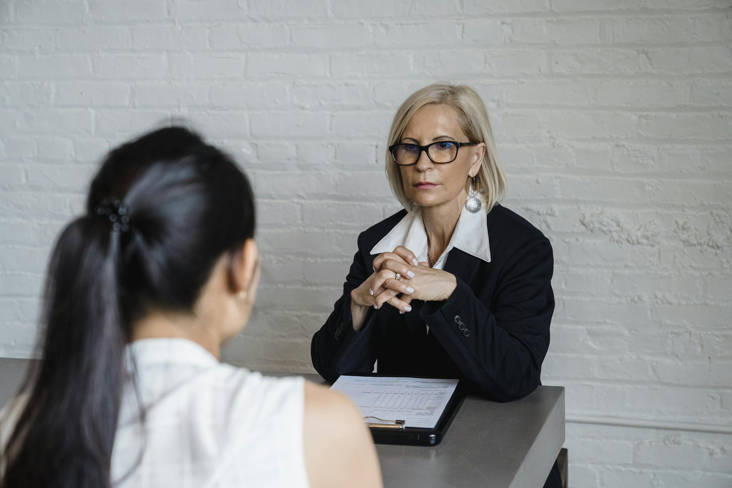 Tangram 6 Professional businesswoman in a black blazer conducting an interview indoors.